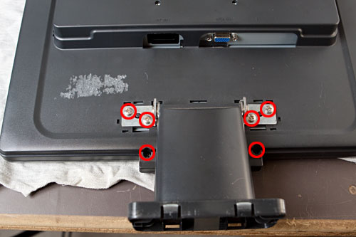 figure 3: the top four screws hold the stand, the bottom two screws secure the rear cover